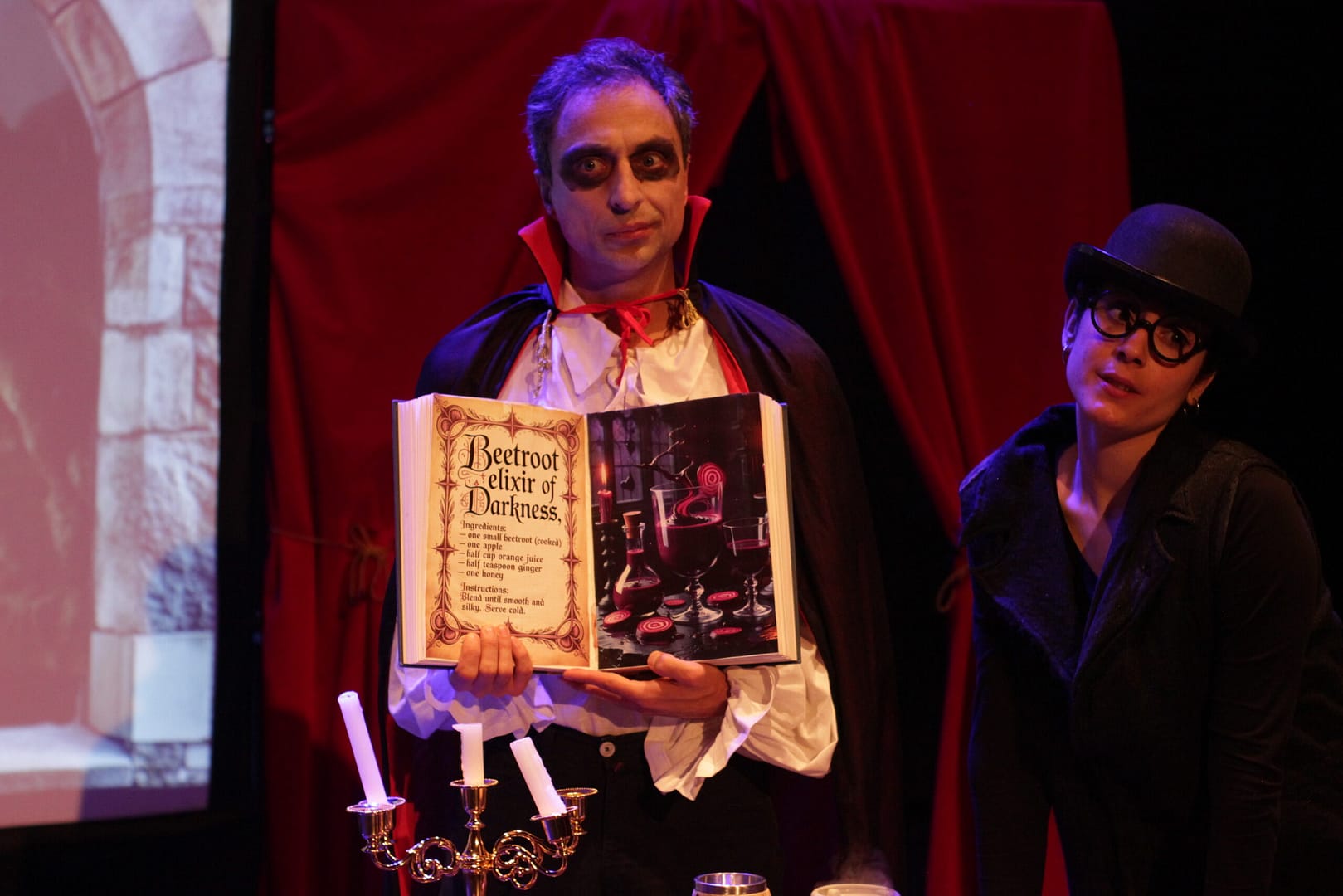 teatro ingles vampiro halloween colegios count macula scaled Count Macula sosteniendo un libro de zumos en una obra de teatro en inglés para colegios, ambiente de Halloween.
